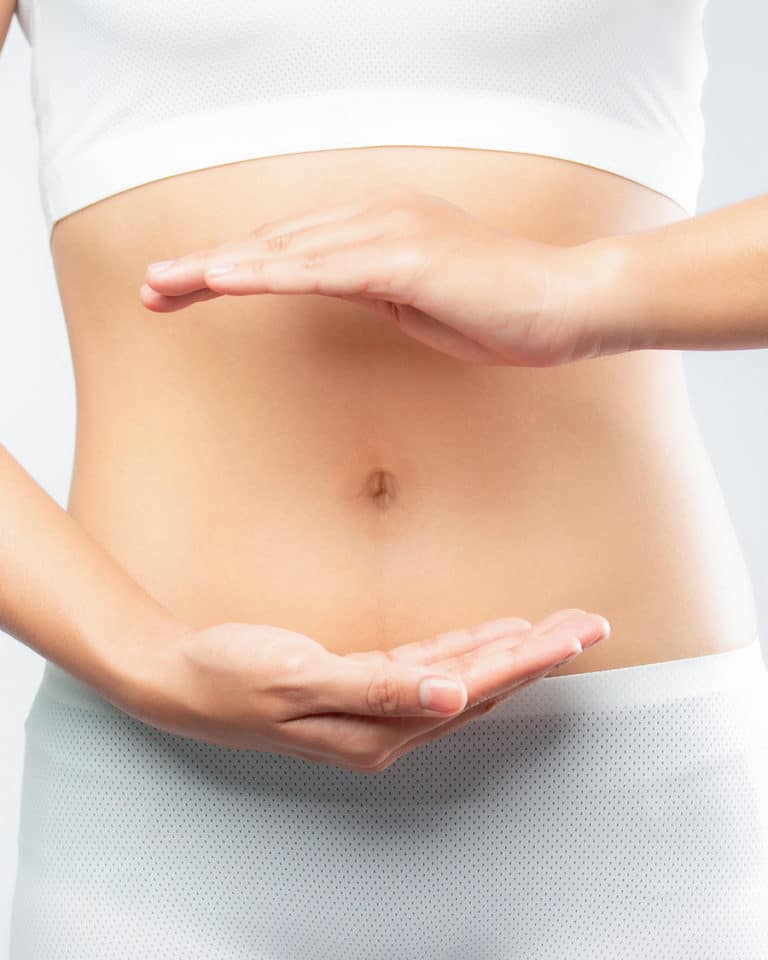 Woman holding her hands over her stomach for digestive health